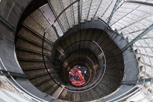 Ein rundes sehr tiefes Treppenhaus von oben fotografiert.